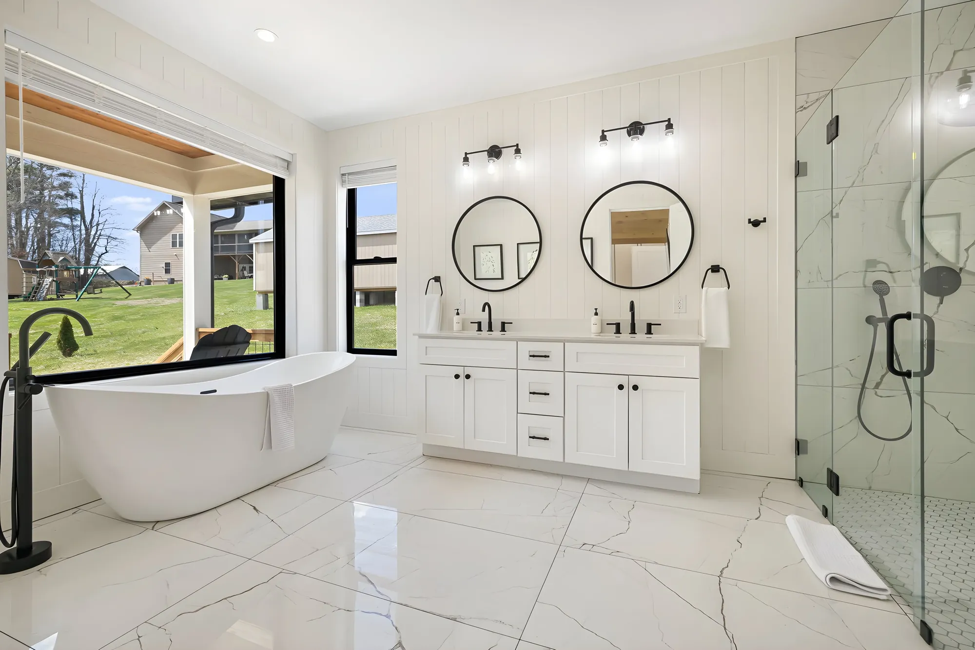 Primary bath at Ridge Glen with a double vanity, a freestanding tub, and a glass shower